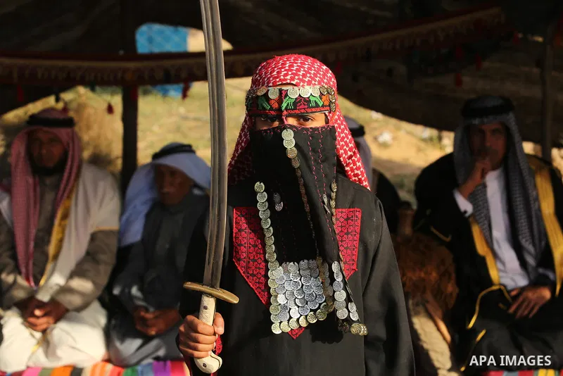 A Palestinian bedouin girl wears traditional dress and holds a sword during a rally marking the 41st anniversary of Land Day, in Deir el-Balah, Central Gaza Strip, on March 31, 2017. Land Day marks the killing of six Ara...
