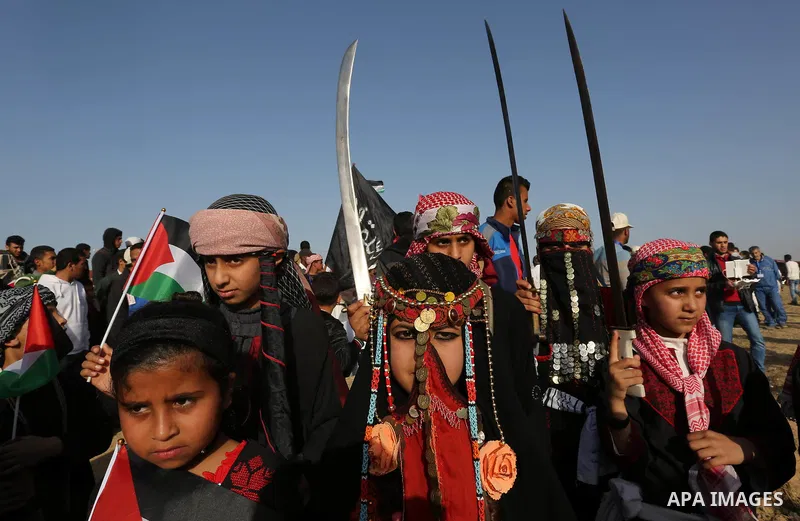 Palestinian bedouin girls wear traditional dress and hold swords during a rally marking the 41st anniversary of Land Day, in Deir el-Balah, Central Gaza Strip, on March 31, 2017. Land Day marks the killing of six Arab Is...