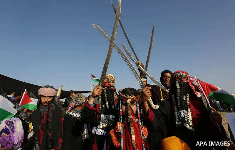 Palestinian bedouin girls wear traditional dress and hold swords during a rally marking the 41st anniversary of Land Day, in Deir el-Balah, Central Gaza Strip, on March 31, 2017. Land Day marks the killing of six Arab Is...