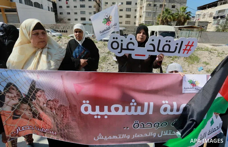 Palestinian activists take part in a rally titled "save Gaza" against the Israeli occupation and Gaza blockade in front of a tower which was destroy during the 50-day war between Israel and Hamas militants in the summer...