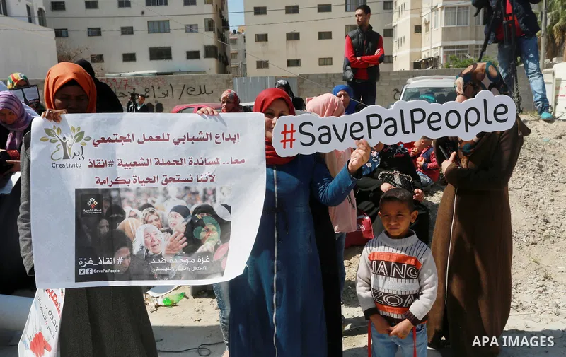 Palestinian activists take part in a rally titled "save Gaza" against the Israeli occupation and Gaza blockade in front of a tower which was destroy during the 50-day war between Israel and Hamas militants in the summer...