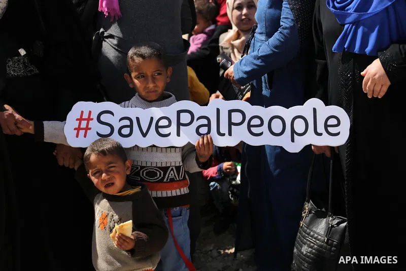 Palestinian activists take part in a rally titled "save Gaza" against the Israeli occupation and Gaza blockade in front of a tower which was destroy during the 50-day war between Israel and Hamas militants in the summer...