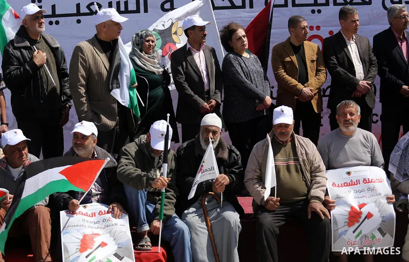 Palestinian activists take part in a rally titled "save Gaza" against the Israeli occupation and Gaza blockade in front of a tower which was destroy during the 50-day war between Israel and Hamas militants in the summer...