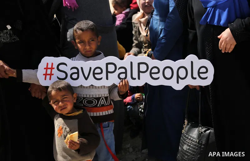 Palestinian activists take part in a rally titled "save Gaza" against the Israeli occupation and Gaza blockade in front of a tower which was destroy during the 50-day war between Israel and Hamas militants in the summer...