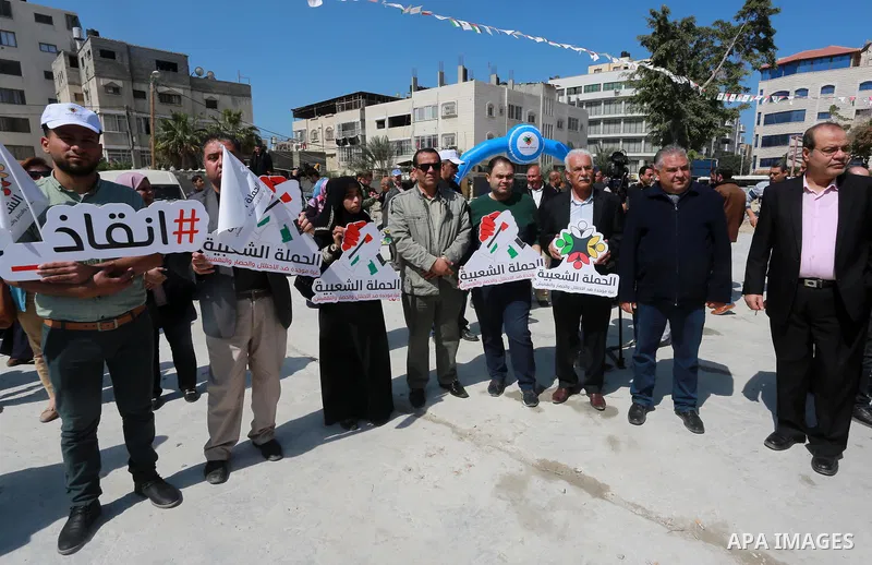 Palestinian activists take part in a rally titled "save Gaza" against the Israeli occupation and Gaza blockade in front of a tower which was destroy during the 50-day war between Israel and Hamas militants in the summer...