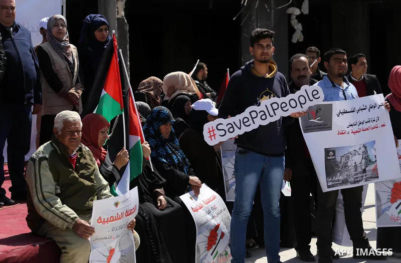 Palestinian activists take part in a rally titled "save Gaza" against the Israeli occupation and Gaza blockade in front of a tower which was destroy during the 50-day war between Israel and Hamas militants in the summer...