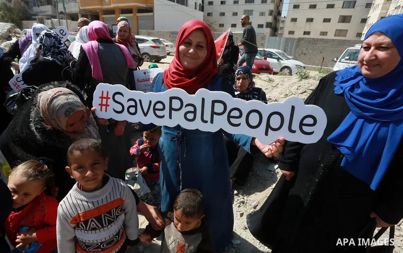 Palestinian activists take part in a rally titled "save Gaza" against the Israeli occupation and Gaza blockade in front of a tower which was destroy during the 50-day war between Israel and Hamas militants in the summer...