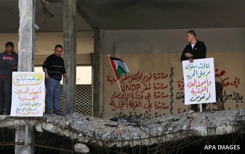Palestinian activists take part in a rally titled "save Gaza" against the Israeli occupation and Gaza blockade in front of a tower which was destroy during the 50-day war between Israel and Hamas militants in the summer...