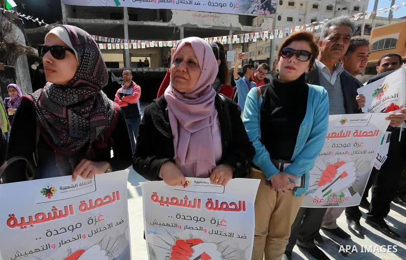 Palestinian activists take part in a rally titled "save Gaza" against the Israeli occupation and Gaza blockade in front of a tower which was destroy during the 50-day war between Israel and Hamas militants in the summer...