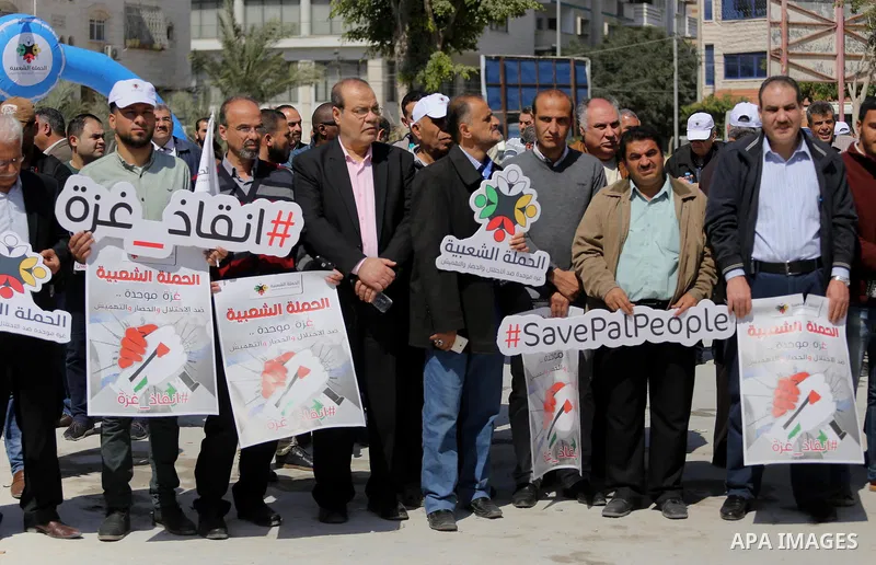 Palestinian activists take part in a rally titled "save Gaza" against the Israeli occupation and Gaza blockade in front of a tower which was destroy during the 50-day war between Israel and Hamas militants in the summer...