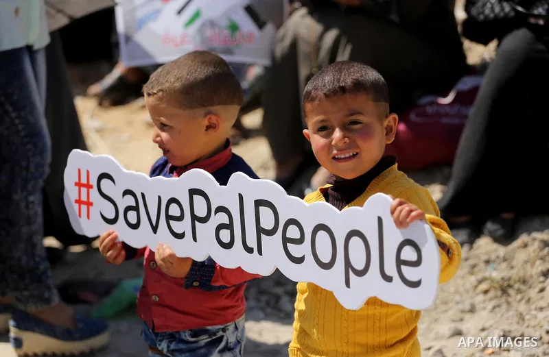Palestinian activists take part in a rally titled "save Gaza" against the Israeli occupation and Gaza blockade in front of a tower which was destroy during the 50-day war between Israel and Hamas militants in the summer...