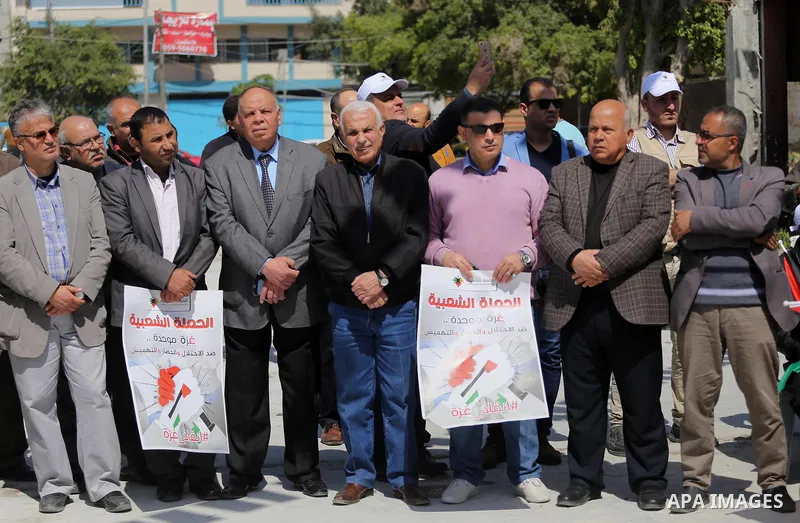 Palestinian activists take part in a rally titled "save Gaza" against the Israeli occupation and Gaza blockade in front of a tower which was destroy during the 50-day war between Israel and Hamas militants in the summer...