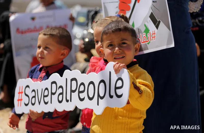Palestinian activists take part in a rally titled "save Gaza" against the Israeli occupation and Gaza blockade in front of a tower which was destroy during the 50-day war between Israel and Hamas militants in the summer...