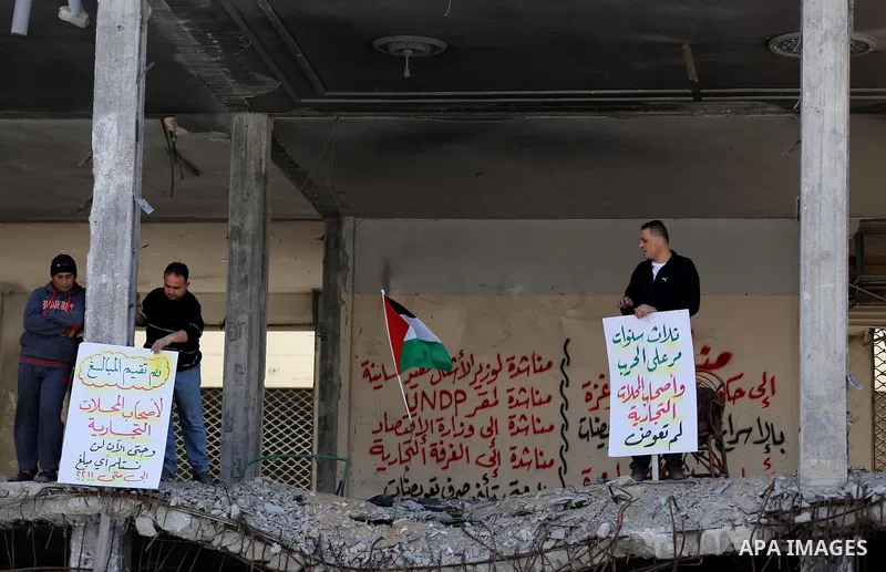 Palestinian activists take part in a rally titled "save Gaza" against the Israeli occupation and Gaza blockade in front of a tower which was destroy during the 50-day war between Israel and Hamas militants in the summer...