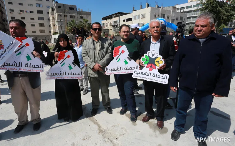 Palestinian activists take part in a rally titled "save Gaza" against the Israeli occupation and Gaza blockade in front of a tower which was destroy during the 50-day war between Israel and Hamas militants in the summer...