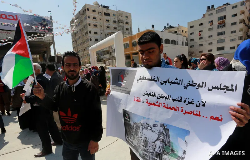 Palestinian activists take part in a rally titled "save Gaza" against the Israeli occupation and Gaza blockade in front of a tower which was destroy during the 50-day war between Israel and Hamas militants in the summer...
