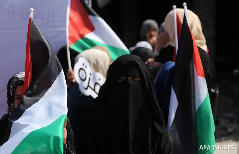 Palestinian activists take part in a rally titled "save Gaza" against the Israeli occupation and Gaza blockade in front of a tower which was destroy during the 50-day war between Israel and Hamas militants in the summer...