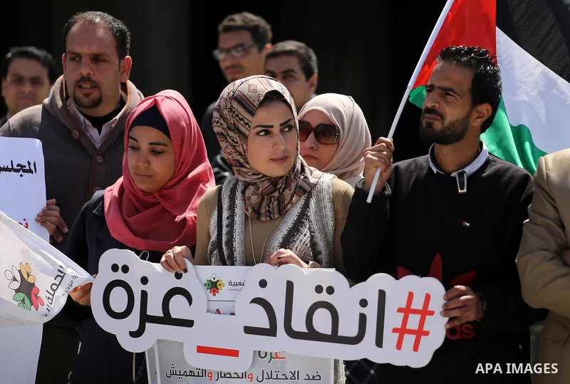Palestinian activists take part in a rally titled "save Gaza" against the Israeli occupation and Gaza blockade in front of a tower which was destroy during the 50-day war between Israel and Hamas militants in the summer...