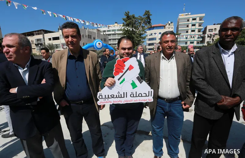 Palestinian activists take part in a rally titled "save Gaza" against the Israeli occupation and Gaza blockade in front of a tower which was destroy during the 50-day war between Israel and Hamas militants in the summer...