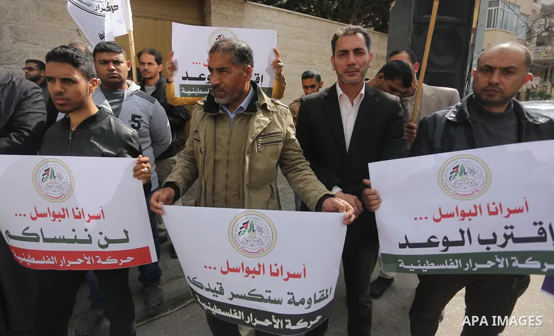 Palestinians hold placards during a protest to show solidarity with Palestinian prisoners held in Israeli Jails, in front of Red cross office in Gaza city, on April 2, 2017. Photo by Mohammed Asad