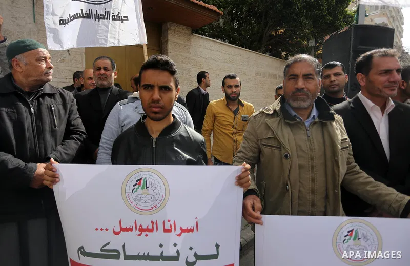 Palestinians hold placards during a protest to show solidarity with Palestinian prisoners held in Israeli Jails, in front of Red cross office in Gaza city, on April 2, 2017. Photo by Mohammed Asad