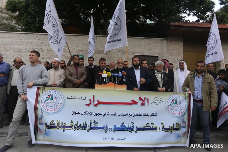 Palestinians hold placards during a protest to show solidarity with Palestinian prisoners held in Israeli Jails, in front of Red cross office in Gaza city, on April 2, 2017. Photo by Mohammed Asad