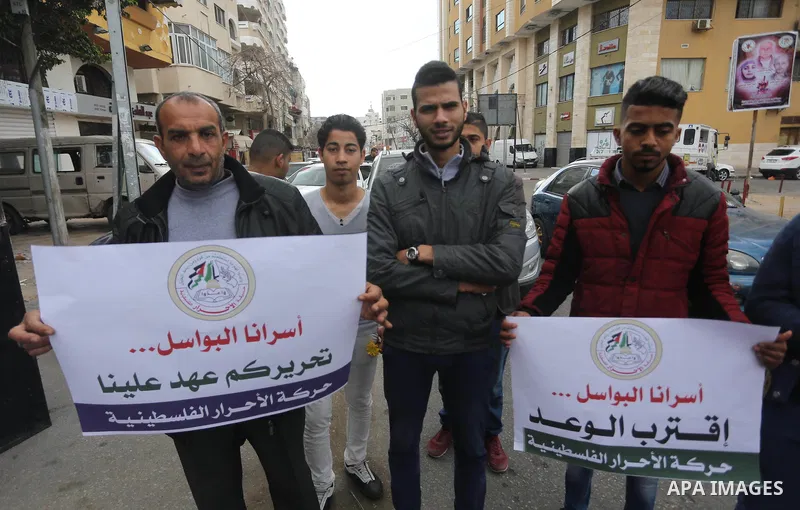 Palestinians hold placards during a protest to show solidarity with Palestinian prisoners held in Israeli Jails, in front of Red cross office in Gaza city, on April 2, 2017. Photo by Mohammed Asad