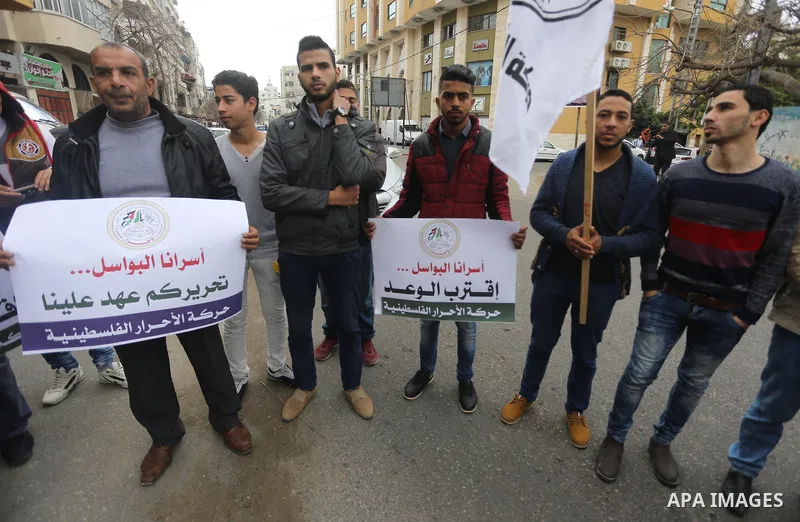 Palestinians hold placards during a protest to show solidarity with Palestinian prisoners held in Israeli Jails, in front of Red cross office in Gaza city, on April 2, 2017. Photo by Mohammed Asad