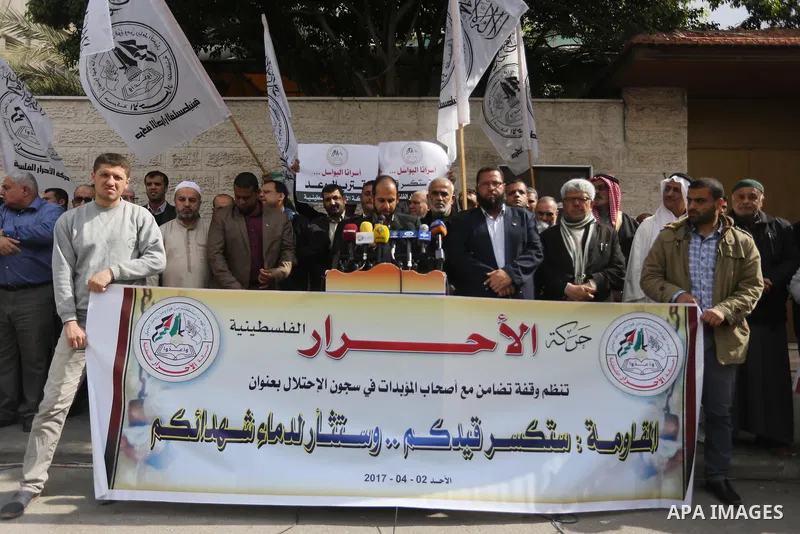 Palestinians hold placards during a protest to show solidarity with Palestinian prisoners held in Israeli Jails, in front of Red cross office in Gaza city, on April 2, 2017. Photo by Mohammed Asad