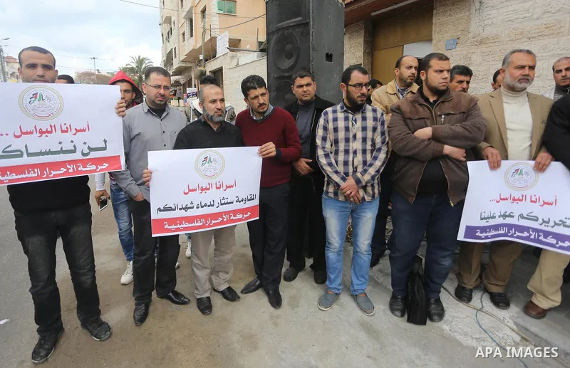 Palestinians hold placards during a protest to show solidarity with Palestinian prisoners held in Israeli Jails, in front of Red cross office in Gaza city, on April 2, 2017. Photo by Mohammed Asad