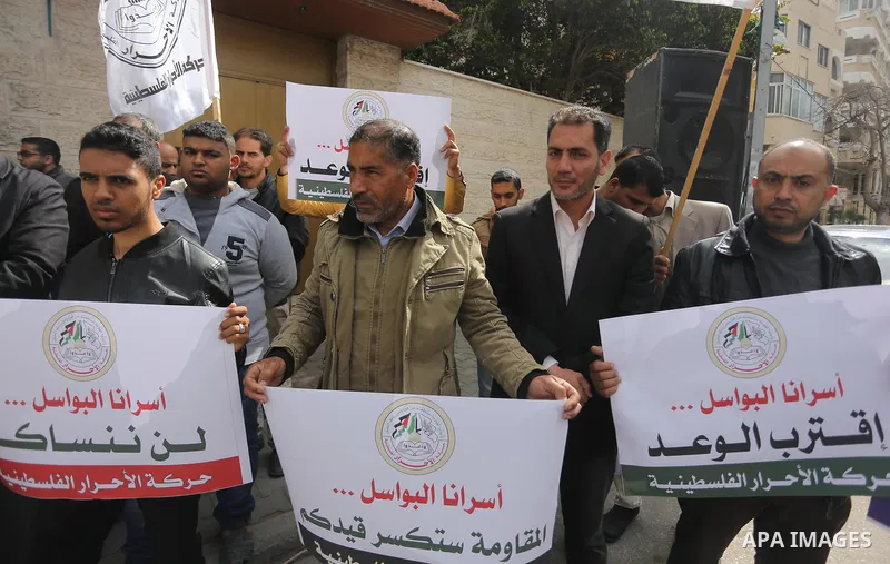 Palestinians hold placards during a protest to show solidarity with Palestinian prisoners held in Israeli Jails, in front of Red cross office in Gaza city, on April 2, 2017. Photo by Mohammed Asad