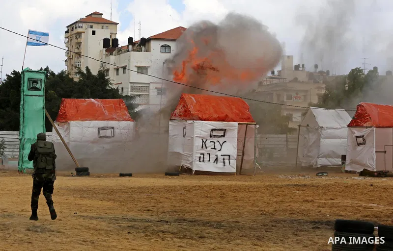 A fire is seen after a mock Israeli tank was blown up during a graduation ceremony from a military school course for Palestinian high-school students organised by the Palestinian security forces in Gaza strip, in Gaza Ci...