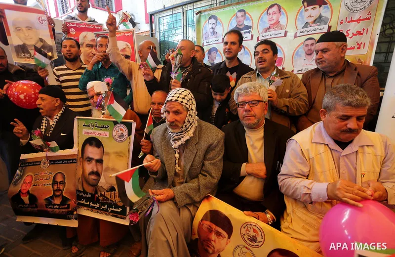 Palestinians hold placards during a protest to show solidarity with Palestinian prisoners held in Israeli Jails, in front of Red cross office in Gaza city, on April 03, 2017. Photo by Mohammed Asad
