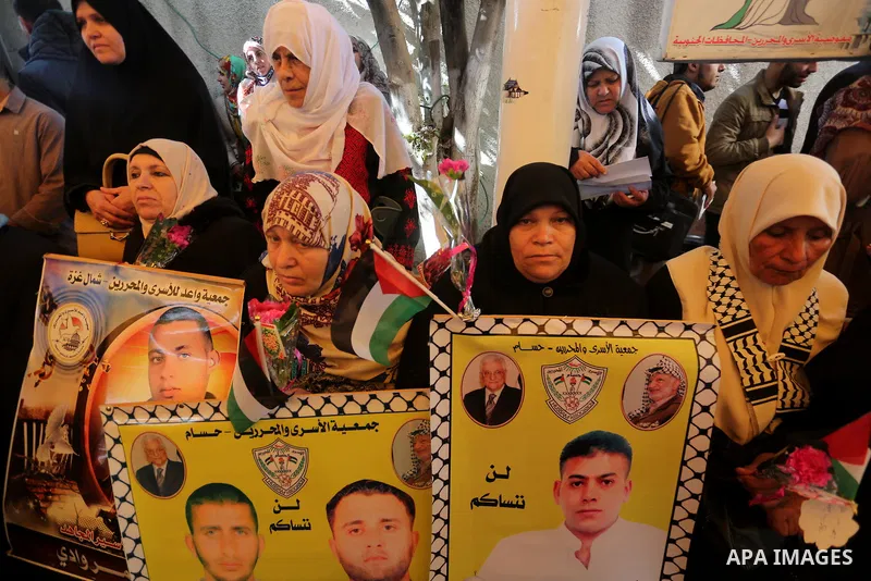 Palestinians hold placards during a protest to show solidarity with Palestinian prisoners held in Israeli Jails, in front of Red cross office in Gaza city, on April 03, 2017. Photo by Mohammed Asad