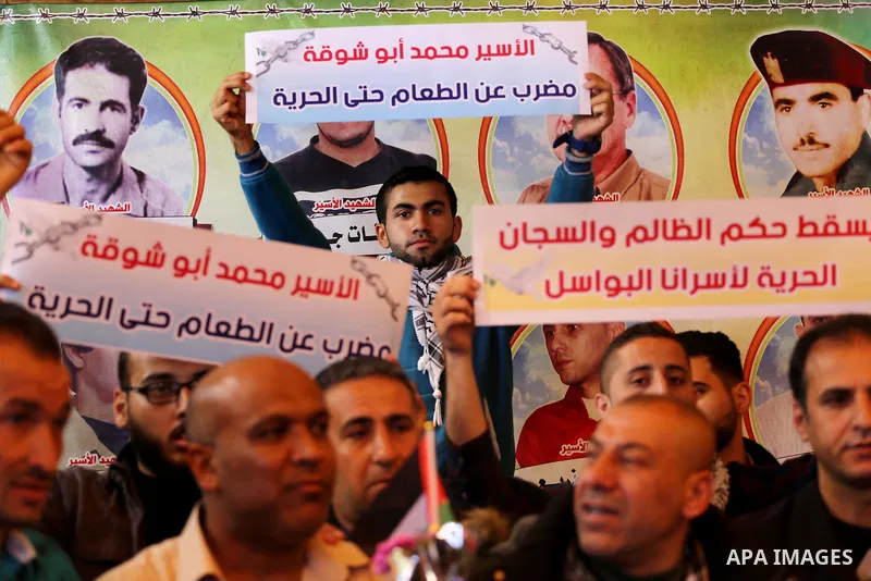 Palestinians hold placards during a protest to show solidarity with Palestinian prisoners held in Israeli Jails, in front of Red cross office in Gaza city, on April 03, 2017. Photo by Mohammed Asad