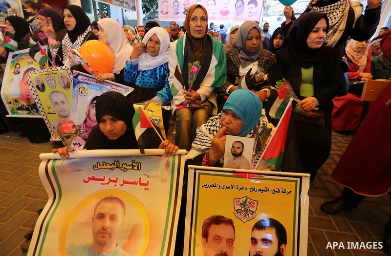 Palestinians hold placards during a protest to show solidarity with Palestinian prisoners held in Israeli Jails, in front of Red cross office in Gaza city, on April 03, 2017. Photo by Mohammed Asad