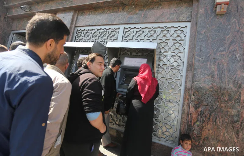 Palestinian employees paid by the Palestinian Authority wait to receive their salaries from an ATM, outside a Bank in Gaza City April 5, 2017. The salaries of Palestinian employees in Gaza strip have been reduced by abou...