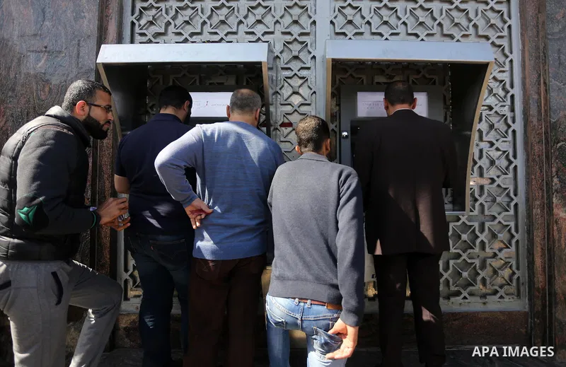 Palestinian employees paid by the Palestinian Authority wait to receive their salaries from an ATM, outside a Bank in Gaza City April 5, 2017. The salaries of Palestinian employees in Gaza strip have been reduced by abou...