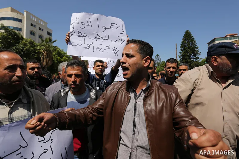 Palestinian employees paid by the Palestinian Authority take part in a protest against the decision of Palestinian goverment to deduct salaries of employees about 30%, in Gaza City April 5, 2017. Photo by Ashraf Amra