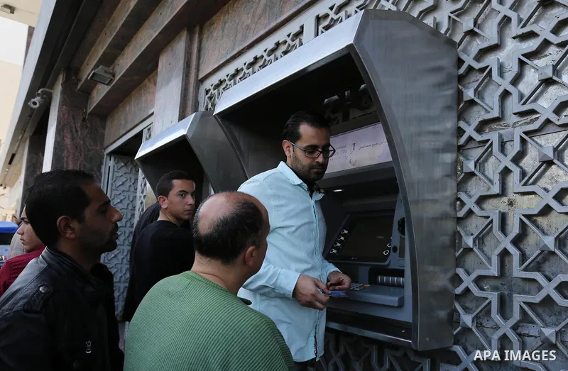 Palestinian employees paid by the Palestinian Authority wait to receive their salaries from an ATM, outside a Bank in Gaza City April 5, 2017. The salaries of Palestinian employees in Gaza strip have been reduced by abou...