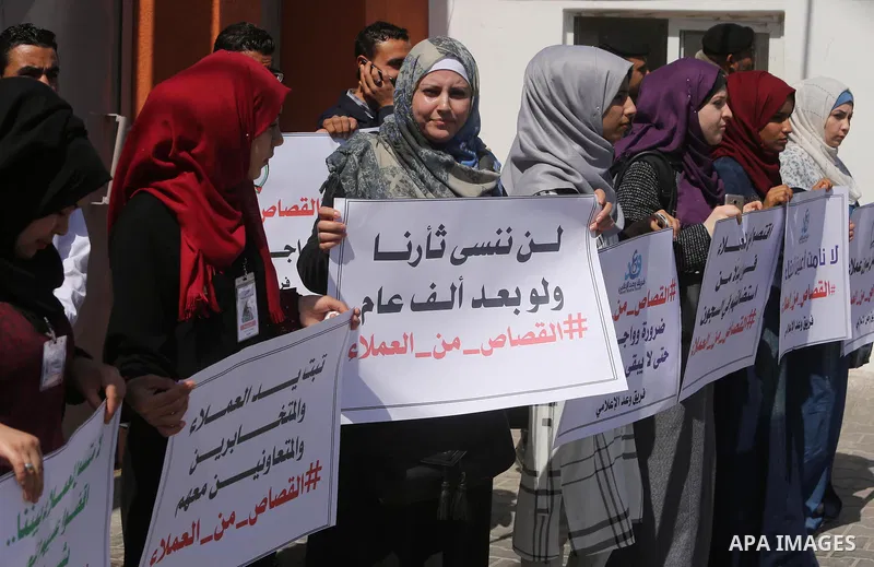 Palestinians hold banners during a protest calling to prosecute collaborators with Israel, in Gaza city on April 05, 2017. Photo by Ashraf Amra