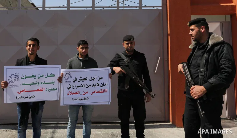 Palestinians hold banners during a protest calling to prosecute collaborators with Israel, in Gaza city on April 05, 2017. Photo by Ashraf Amra