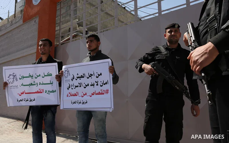 Palestinians hold banners during a protest calling to prosecute collaborators with Israel, in Gaza city on April 05, 2017. Photo by Ashraf Amra