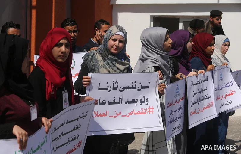 Palestinians hold banners during a protest calling to prosecute collaborators with Israel, in Gaza city on April 05, 2017. Photo by Ashraf Amra