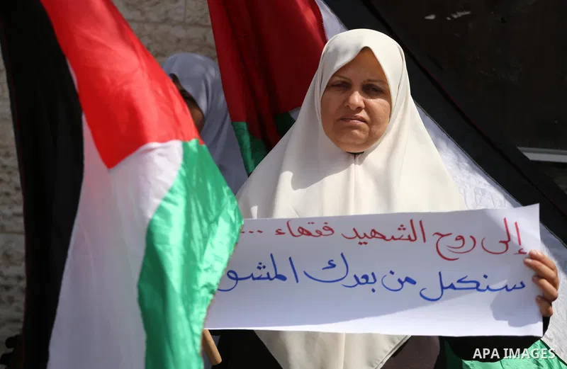 Palestinian women hold banners during a protest to mark Palestinian Prisoner Day, in front of Red cross office in Gaza city, on April 08, 2017. Photo by Mohammed Asad