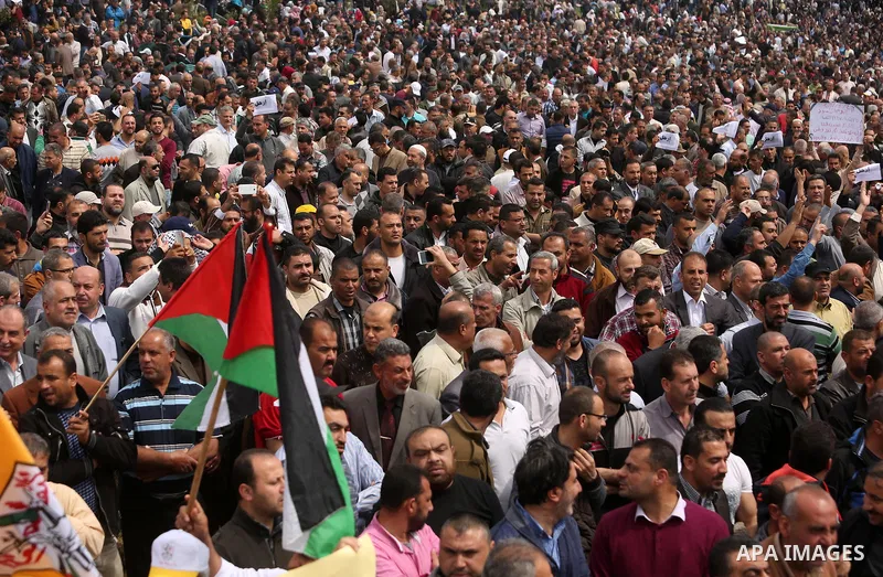 Palestinians, employed by the Palestinian Authority, chant slogans and wave placards during a demonstration against the decision to reduce their salaries in Gaza City on April 8, 2017. Photo by Ashraf Amra