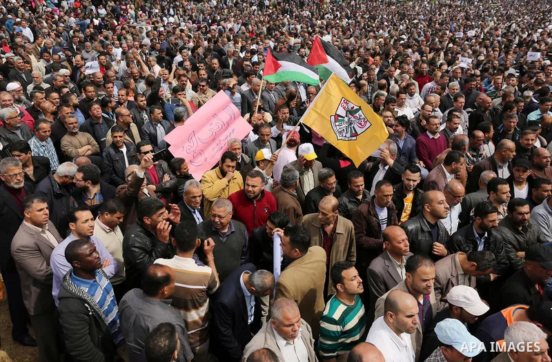 Palestinians, employed by the Palestinian Authority, chant slogans and wave placards during a demonstration against the decision to reduce their salaries in Gaza City on April 8, 2017. Photo by Ashraf Amra