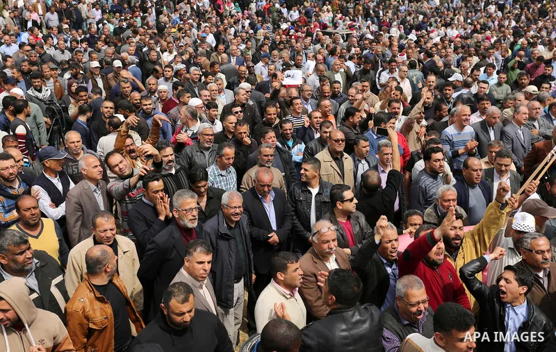 Palestinians, employed by the Palestinian Authority, chant slogans and wave placards during a demonstration against the decision to reduce their salaries in Gaza City on April 8, 2017. Photo by Ashraf Amra
