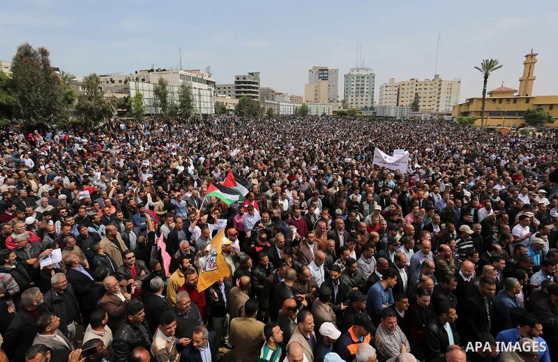 Palestinians, employed by the Palestinian Authority, chant slogans and wave placards during a demonstration against the decision to reduce their salaries in Gaza City on April 8, 2017. Photo by Ashraf Amra
