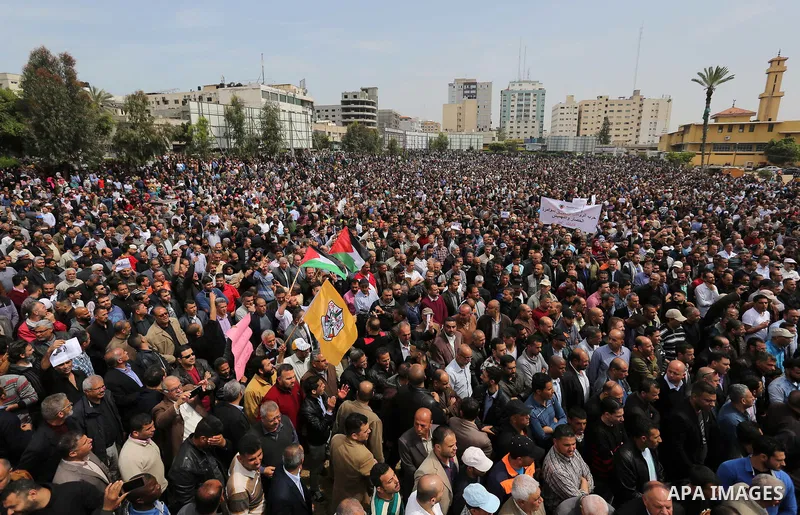 Palestinians, employed by the Palestinian Authority, chant slogans and wave placards during a demonstration against the decision to reduce their salaries in Gaza City on April 8, 2017. Photo by Ashraf Amra